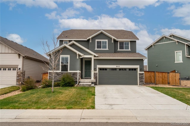 craftsman inspired home with fence, stone siding, concrete driveway, a garage, and a front yard