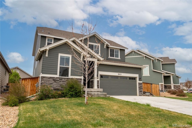 craftsman-style house featuring stone siding, driveway, a front yard, and fence