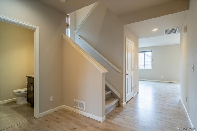 stairway with recessed lighting, baseboards, visible vents, and wood finished floors