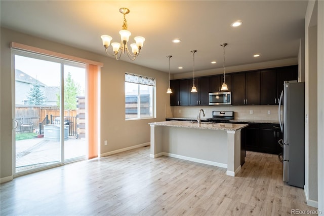 kitchen with plenty of natural light, stainless steel appliances, light wood-style flooring, and a sink