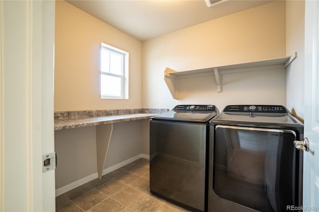 washroom with baseboards, washing machine and dryer, and laundry area