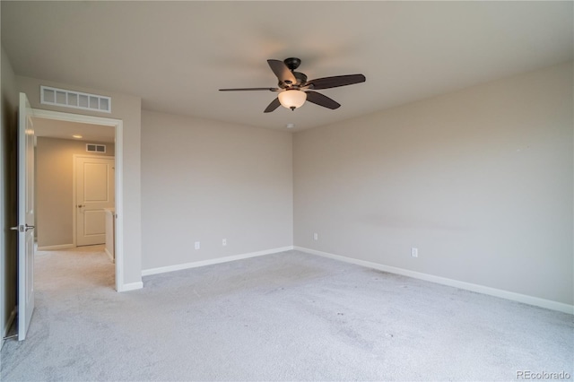 unfurnished room with light colored carpet, baseboards, a ceiling fan, and visible vents