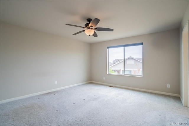 unfurnished room with baseboards, light carpet, and ceiling fan