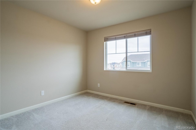 spare room with carpet, visible vents, and baseboards