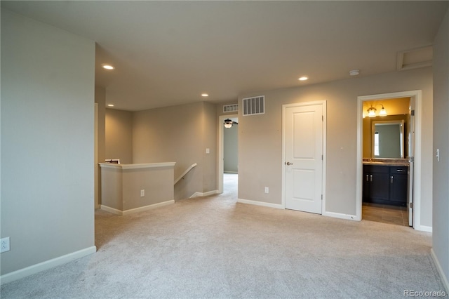 spare room with carpet, visible vents, and recessed lighting