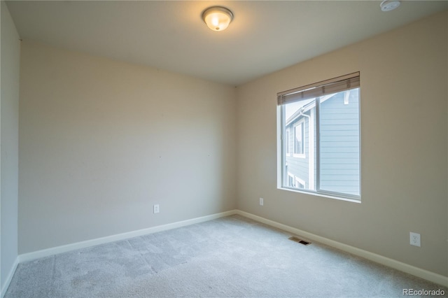 unfurnished room with visible vents, baseboards, and light carpet