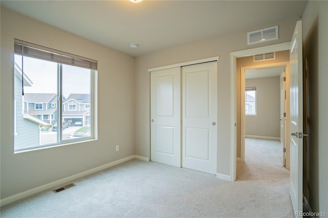 unfurnished bedroom featuring carpet and visible vents