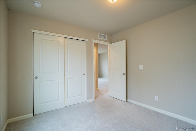 unfurnished bedroom with carpet, a closet, baseboards, and visible vents