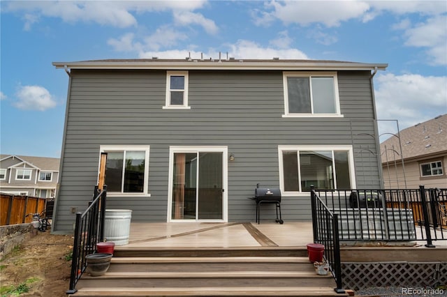 back of property with fence and a deck