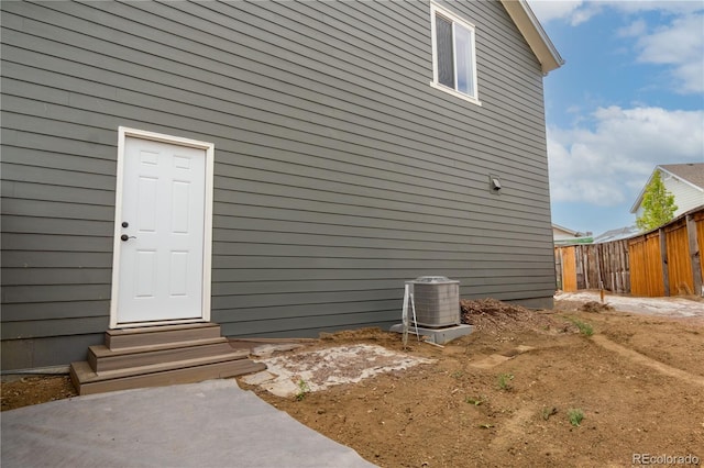 exterior space with central air condition unit and fence