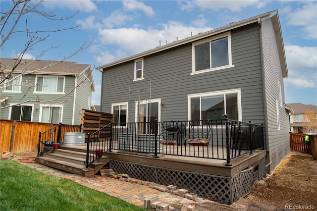 rear view of property with a deck and fence