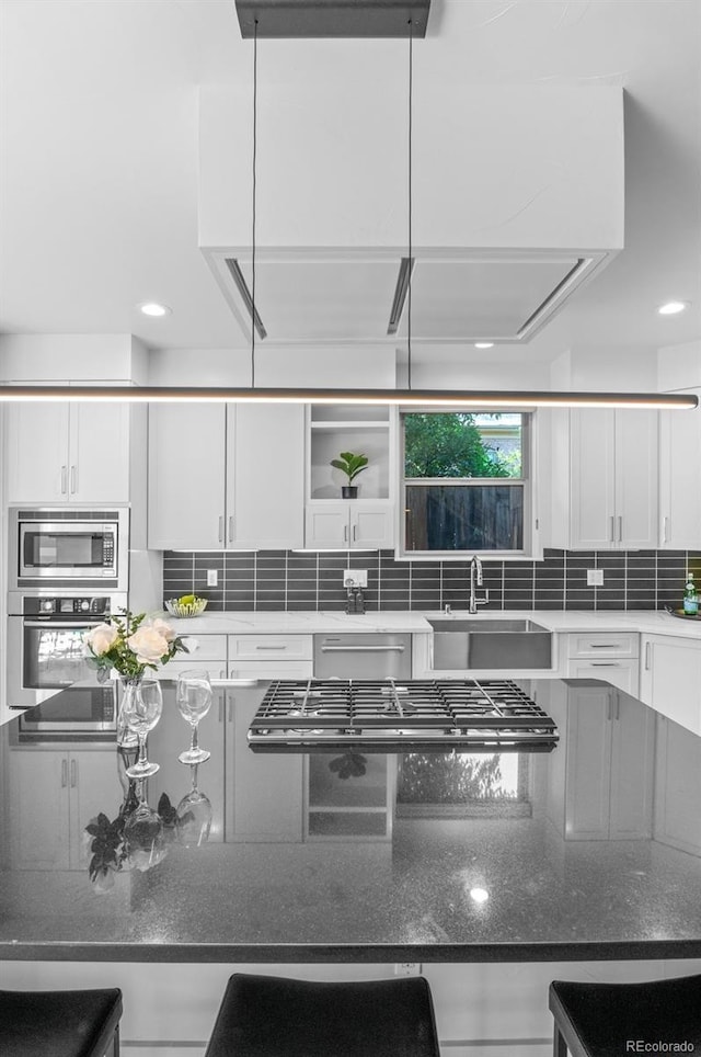 2745 Java Ct, Denver, CO 80211 - kitchen featuring stainless steel appliances, white cabinetry, decorative backsplash, dark stone counters, and recessed lighting