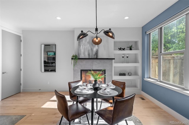 2745 Java Ct, Denver, CO 80211 - dining space featuring light wood-type flooring, a tiled fireplace, recessed lighting, and built in shelves