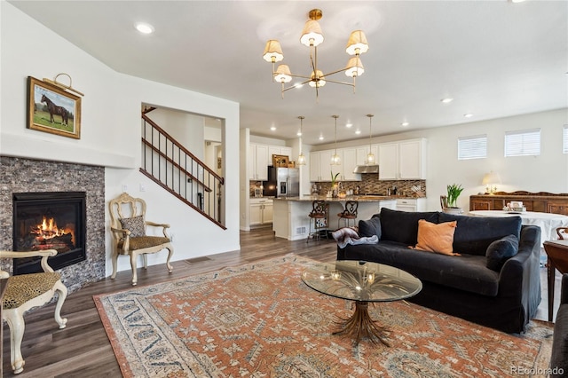 14938 Vienna Cir, Parker, CO 80134 - living room featuring dark wood finished floors, a chandelier, a glass covered fireplace, and recessed lighting