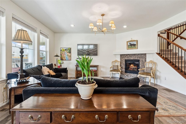 14938 Vienna Cir, Parker, CO 80134 - living room with stairway, a glass covered fireplace, a chandelier, wood finished floors, and recessed lighting