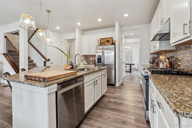 14938 Vienna Cir, Parker, CO 80134 - kitchen featuring under cabinet range hood, stainless steel appliances, a sink, backsplash, and white cabinets