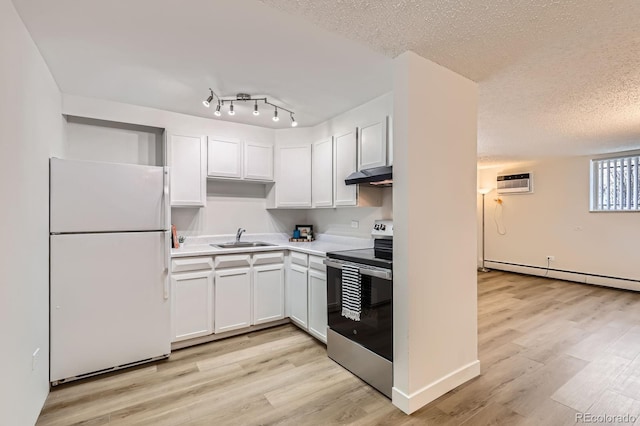 kitchen featuring stainless steel range with electric stovetop, a sink, a baseboard heating unit, under cabinet range hood, and freestanding refrigerator