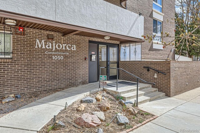 entrance to property featuring brick siding