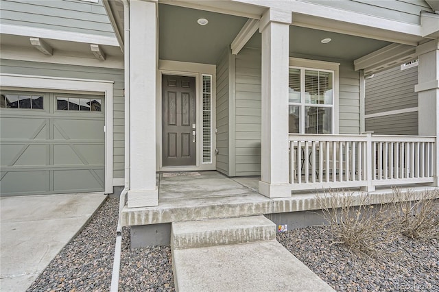view of exterior entry featuring a garage and covered porch