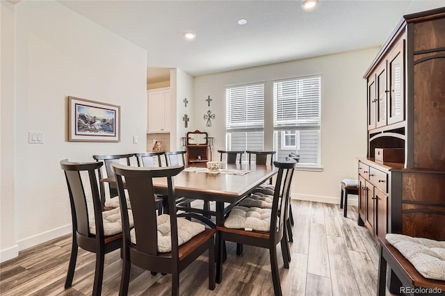 dining room with a wealth of natural light, light wood finished floors, and baseboards