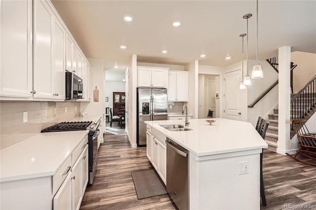 kitchen with a sink, dark wood-style flooring, recessed lighting, stainless steel appliances, and decorative backsplash