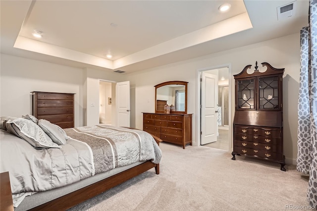 bedroom with a tray ceiling, recessed lighting, light colored carpet, and visible vents