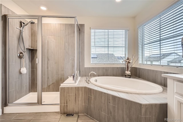 bathroom with a bath, a stall shower, and recessed lighting