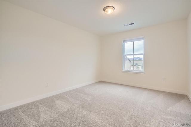 empty room featuring light carpet, baseboards, and visible vents
