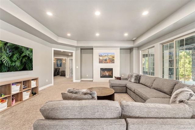 living room featuring a tray ceiling and light carpet