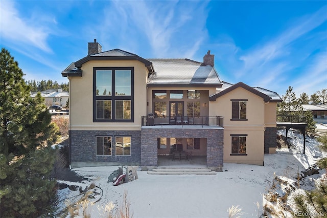 snow covered house with a patio