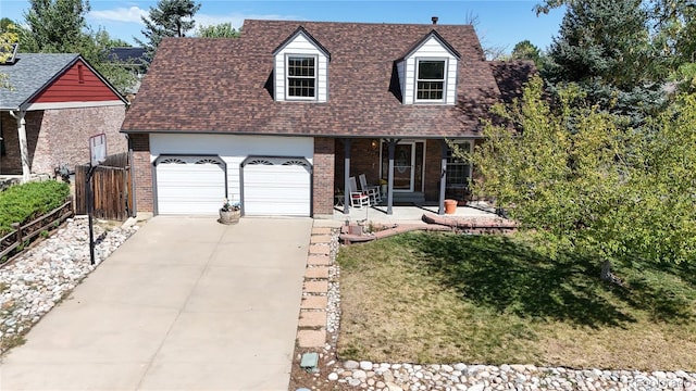 cape cod home with a garage and a front yard