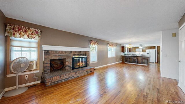 living room featuring a textured ceiling, hardwood / wood-style floors, and a fireplace