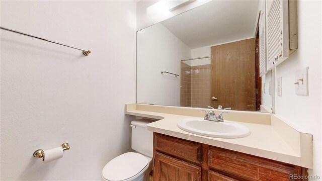 bathroom with vanity, toilet, and walk in shower