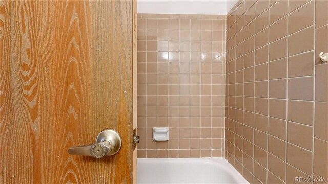 bathroom featuring tiled shower / bath