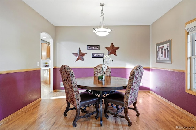 5683 Fig Way, Arvada, CO 80002 - dining space with light wood-type flooring, arched walkways, baseboards, and plenty of natural light