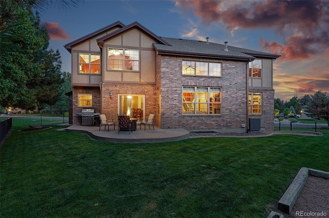 5683 Fig Way, Arvada, CO 80002 - back of house at dusk with central air condition unit, a patio area, brick siding, and stucco siding