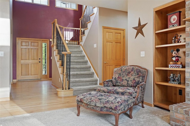 5683 Fig Way, Arvada, CO 80002 - foyer entrance with baseboards, carpet, stairs, a towering ceiling, and wood finished floors