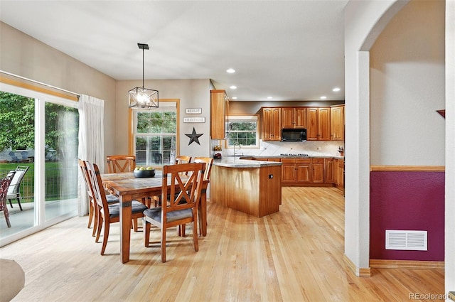 5683 Fig Way, Arvada, CO 80002 - dining space featuring light wood-style floors, arched walkways, recessed lighting, a chandelier, and baseboards