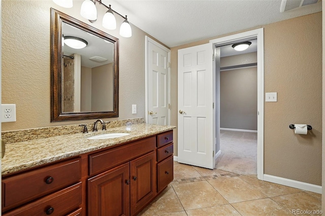 5683 Fig Way, Arvada, CO 80002 - full bath featuring vanity, tile patterned flooring, baseboards, and a textured ceiling