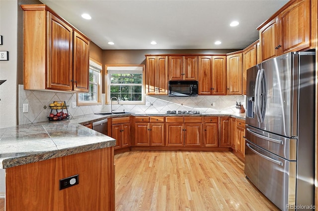 5683 Fig Way, Arvada, CO 80002 - kitchen featuring appliances with stainless steel finishes, brown cabinets, light wood-style floors, a peninsula, and recessed lighting