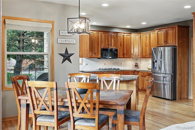 5683 Fig Way, Arvada, CO 80002 - kitchen with stainless steel appliances, light wood-style flooring, backsplash, a chandelier, and recessed lighting