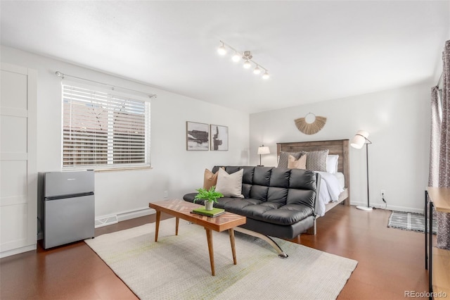 bedroom with baseboards and freestanding refrigerator