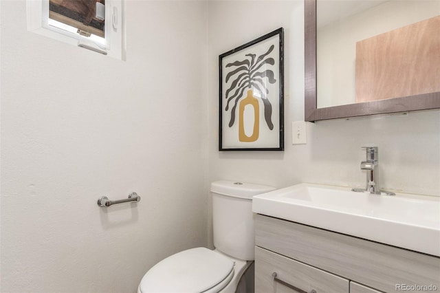 half bathroom featuring toilet and vanity