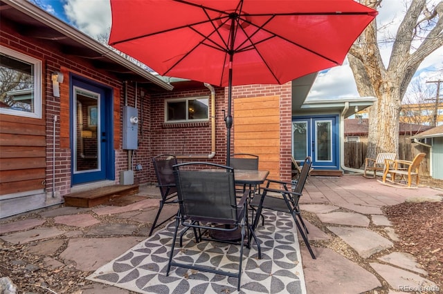 view of patio with outdoor dining area and fence