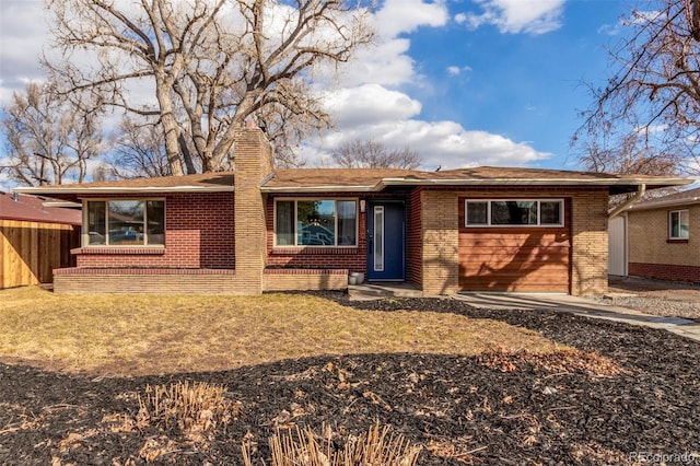 ranch-style house featuring brick siding, a chimney, and fence