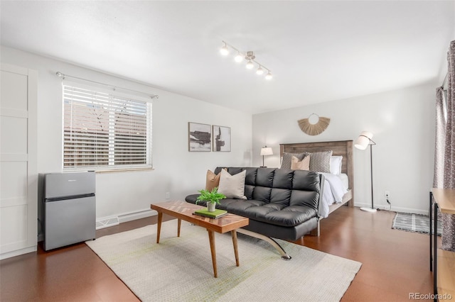 bedroom featuring baseboards and freestanding refrigerator