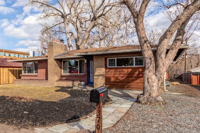 single story home with a chimney, a shingled roof, fence, and brick siding