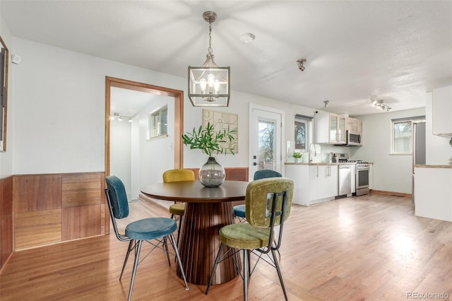 dining space with light wood-type flooring and a chandelier
