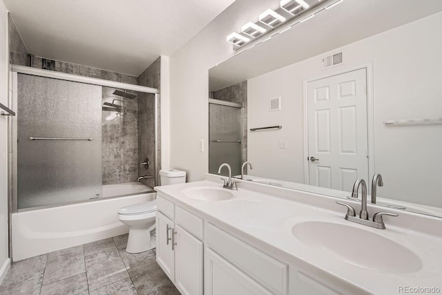 full bathroom featuring combined bath / shower with glass door, vanity, and toilet