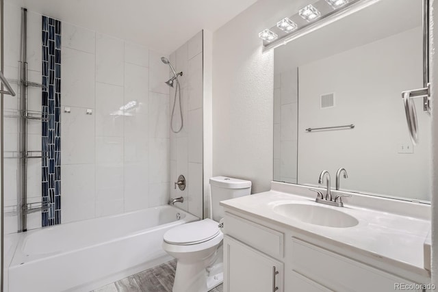 full bathroom with hardwood / wood-style floors, vanity, toilet, and tiled shower / bath